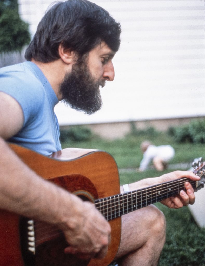 Fred Sachs strums guitar